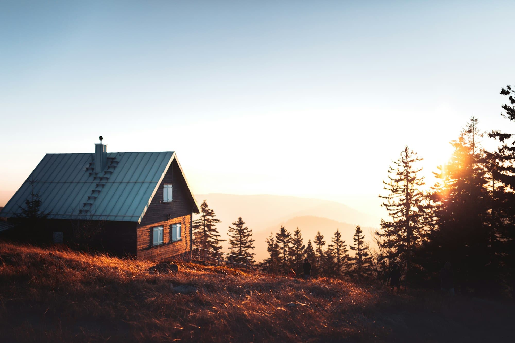 Cabin at dusk above a forested ridgeline